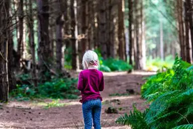 blonde-hair-young-girl-standing-alone-in-rendlesham-forest-suffolk