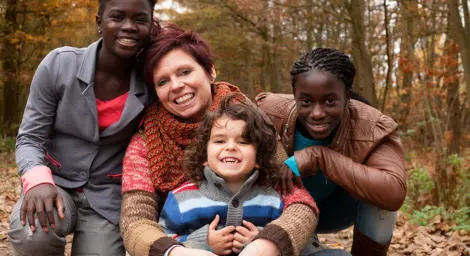 red-hair-woman-with-foster-family-smiling-in-forest